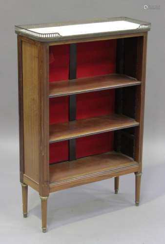 An early 20th century French walnut open bookcase with gilt metal mounts, the white marble top above