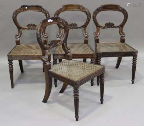 A set of four Regency rosewood dining chairs with carved scroll decoration, the caned seats raised