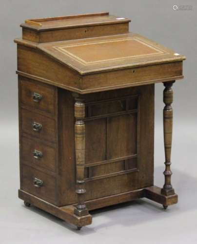 An Edwardian walnut Davenport, the letter rack and pen compartment above a hinged writing slope, the