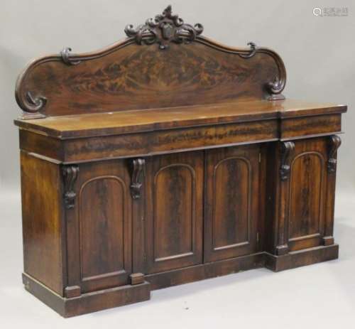A Victorian mahogany sideboard, the arched back with a carved surmount, fitted with frieze drawers