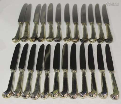 A set of twelve Elizabeth II silver handled pistol style table knives and twelve matching dessert