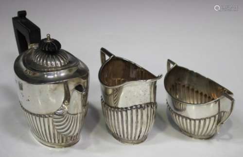 A late Victorian and later silver harlequin three-piece bachelor's tea set of oval form with half-