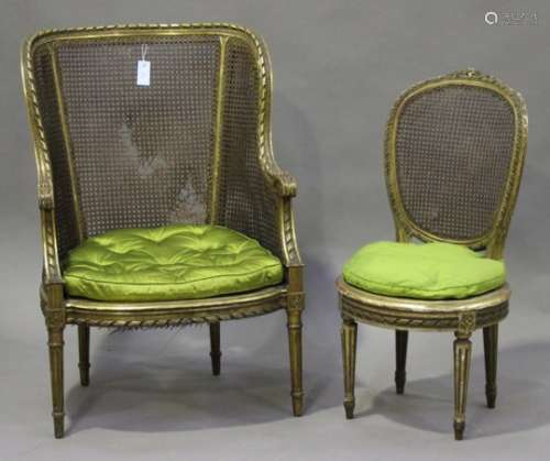 A 20th century Louis XVI style giltwood bergère armchair with caned seat and back, on fluted