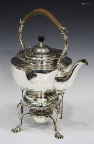 An Edwardian silver spirit kettle on stand, the circular kettle with overhead handle, above a