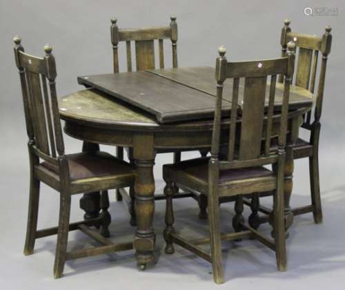 An early 20th century oak oval extending dining table with two extra leaves, on turned and block