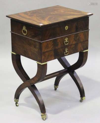 A French Empire figured mahogany work table with gilt metal mounts, the hinged lid above two