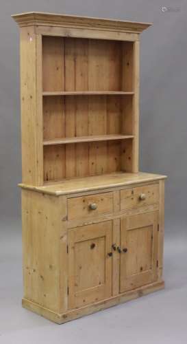 A Victorian stripped pine dresser, the shelf back above two drawers and a pair of cupboard doors, on