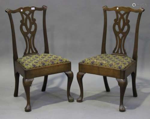 A pair of George II walnut dining chairs, the pierced splat backs above drop-in woolwork seats,