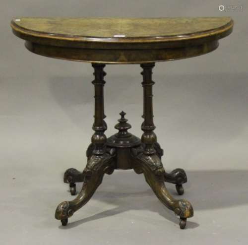 A Victorian burr walnut demi-lune card table, the fold-over top with moulded edge, on four turned