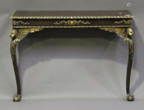 An early/mid-20th century walnut and gilt painted console table with carved decoration, on