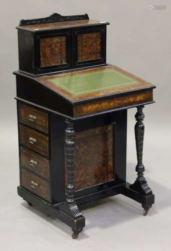 A Victorian amboyna and ebonized Davenport, the back fitted with two doors above a sloping