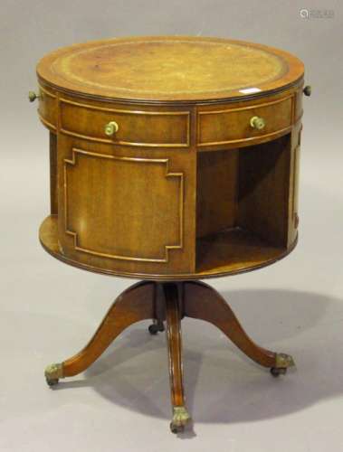 A 20th century reproduction mahogany revolving bookcase, the circular top inset with a gilt-tooled