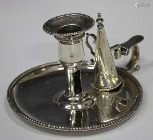 A George III silver chamberstick with detachable nozzle and conical snuffer, on a circular base with