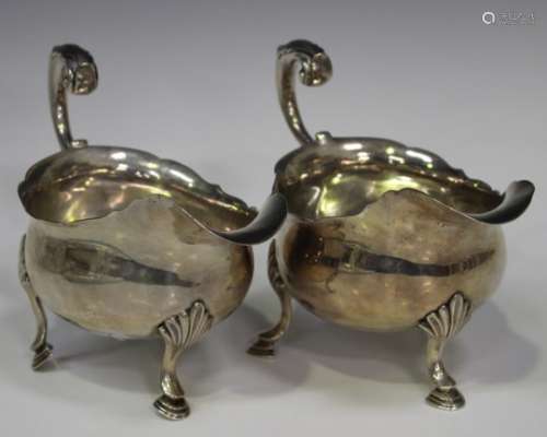 A pair of George III silver sauce boats, each with a foliate capped flying scroll handle and