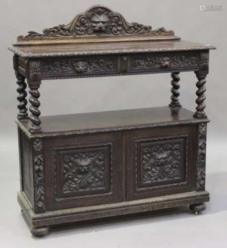 A late 19th century carved oak buffet, fitted with two drawers above an open shelf and a pair of