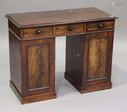 A small 19th century mahogany twin pedestal desk, the top with a moulded edge and fitted with
