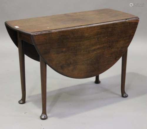 A George III mahogany oval drop-flap supper table, raised on turned tapering legs with pad feet,