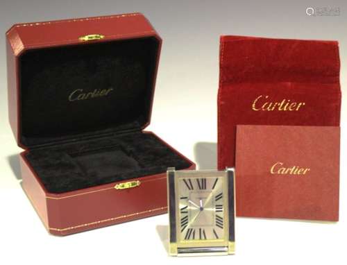 A Cartier chrome plated rectangular cased travelling alarm clock, the silvered dial with black Roman