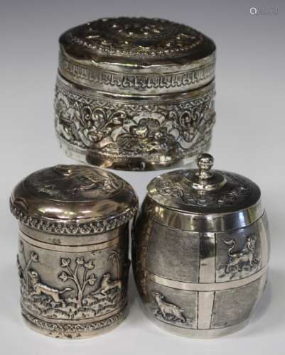 Three Burmese white metal boxes and covers, one of barrel form, embossed with different zoological