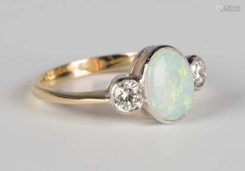 A gold, diamond and opal ring, collet set with an oval opal between two circular cut diamonds,