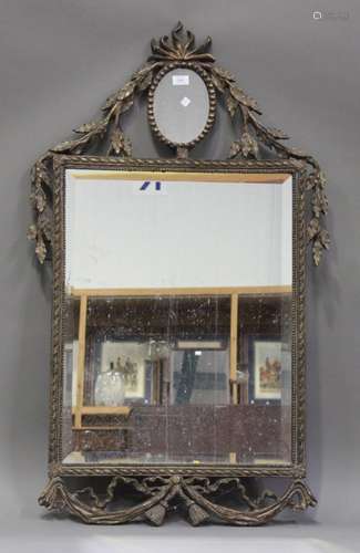 A modern Neoclassical style gilt composite wall mirror with a bevelled glass, the frame with