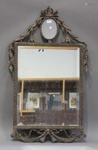 A modern Neoclassical style gilt composite wall mirror with a bevelled glass, the frame with