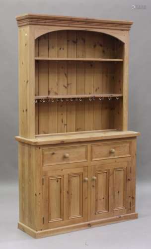A late 20th century pine dresser, the shelf back above two drawers and a cupboard, on a plinth base,