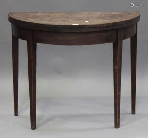 A George III mahogany demi-lune fold-over card table, raised on square tapering legs, height 75cm,