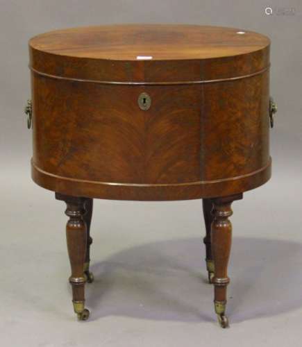 An early 19th century oval figured mahogany cellaret, the hinged lid raised on turned legs with