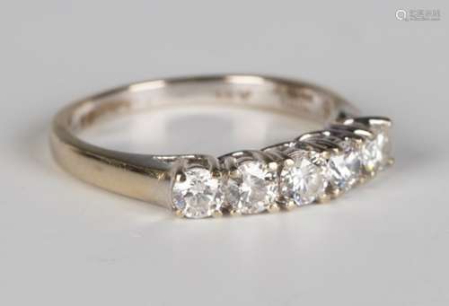 An 18ct white gold and diamond five stone ring, claw set with a row of circular cut diamonds, ring