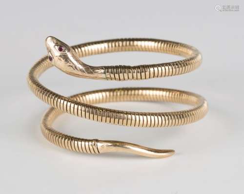 A 9ct gold coiled snake bangle with red gem set eyes, inside diameter 6.5cm.Buyer’s Premium 29.4% (