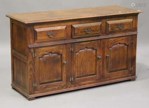 A modern oak dresser base, fitted with three drawers above cupboards, on block feet, height 80cm,
