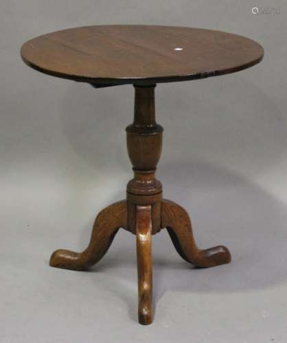 A George III provincial oak circular tip-top wine table, on a turned column and tripod legs,