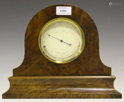 A brass cased circular aneroid barometer, the silvered dial with curved mercury thermometer,