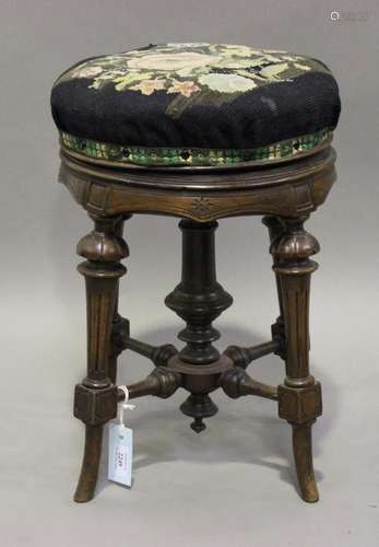 A late Victorian Aesthetic period walnut revolving piano stool, raised on fluted legs, height 50cm.