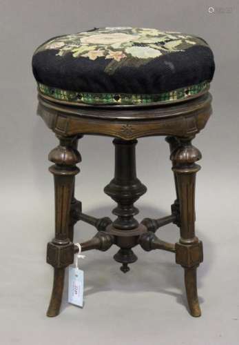 A late Victorian Aesthetic period walnut revolving piano stool, raised on fluted legs, height 50cm.