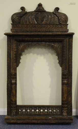 A 20th century Eastern hardwood mirror frame, profusely carved with a large domed pediment above