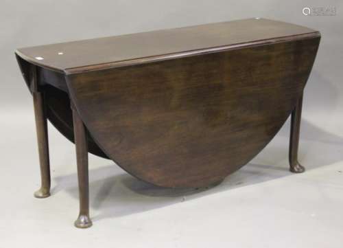 A large George III mahogany oval drop-flap dining table, raised on turned legs and pad feet,