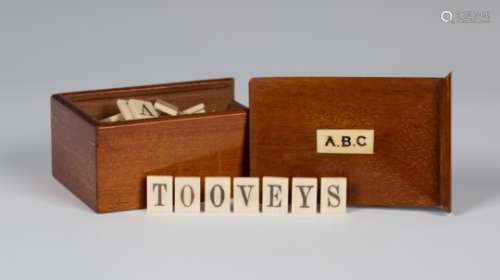 A late Victorian mahogany cased ivory alphabet set, each tile inscribed in black ink, the sliding