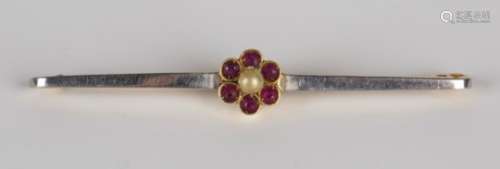 An 18ct gold, seed pearl and red gem set bar brooch, the bar centred by a flowerhead cluster,