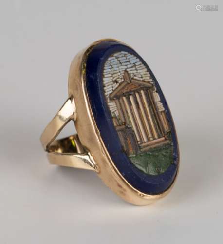 A gold ring, mounted with an oval micro-mosaic depicting a classical temple between split shoulders,