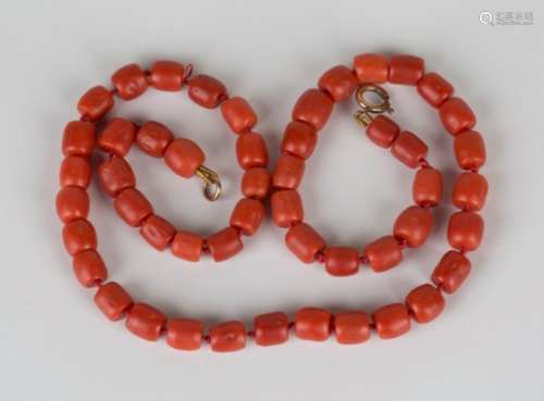 A single row necklace of barrel shaped coral beads on a boltring clasp, length 44cm.Buyer’s