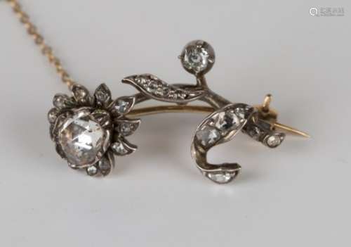 A Victorian diamond brooch, designed as a single flower spray, mounted with a large rose cut diamond