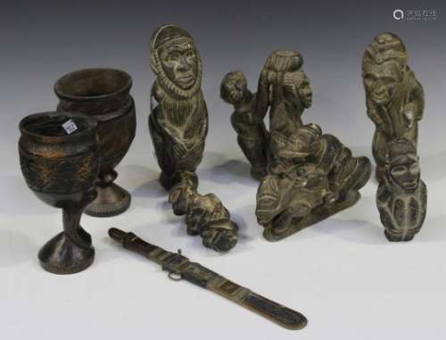 A group of African carved soapstone figural carvings, two carved wooden goblets and a dagger.Buyer’s