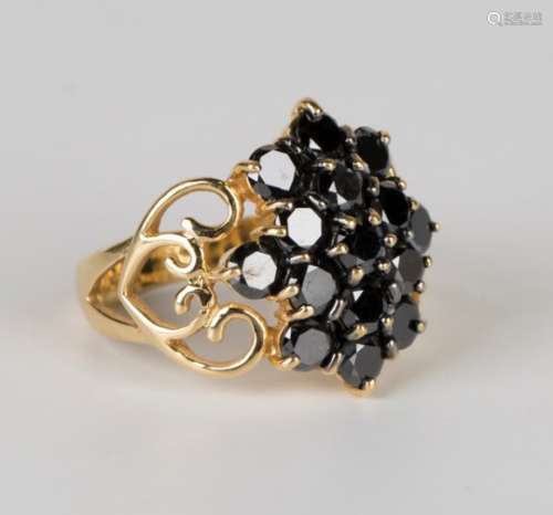 An 18ct gold and black diamond cluster ring, claw set with circular cut black diamonds between