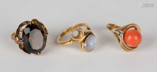 A gold ring, claw set with an oval cut smoky quartz, detailed 'K14', a gold and cabochon moonstone