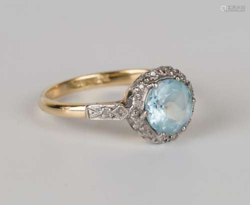 A gold, platinum, blue topaz and diamond cluster ring, claw set with the circular cut blue topaz