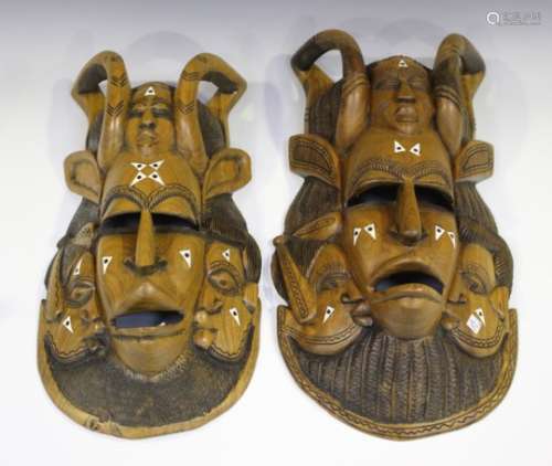 A pair of 20th century West African carved hardwood masks, inlaid in bone, length 52cm, together
