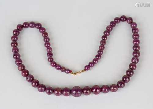 A single row necklace of graduated ruby beads on a gold sprung hook shaped clasp, detailed '585',