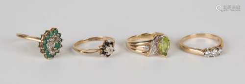 A 9ct gold, peridot and diamond ring, a 9ct gold and diamond three stone ring, a 9ct gold emerald